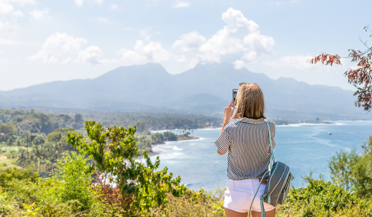 Randonneuse photographiant un paysage de montagne avec son smartphone