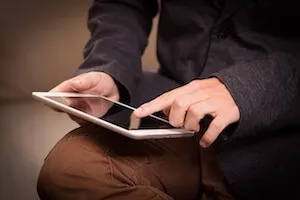 Photo d'un homme qui surfe sur internet avec une tablette
