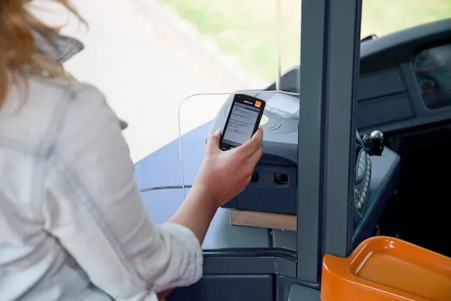 Une femme valide son smartphone en guise de titre de transport