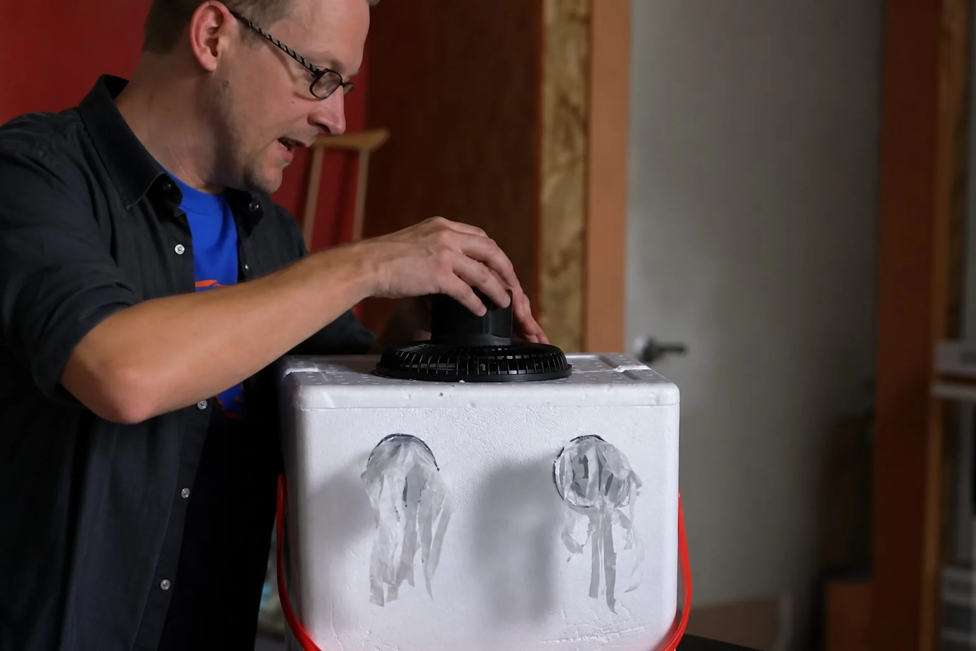 Aus einer Kühlbox, einem Ventilator und Eis selbstgebaute Klimaanlage mit Flaschenhälsen als Luftauslässen
